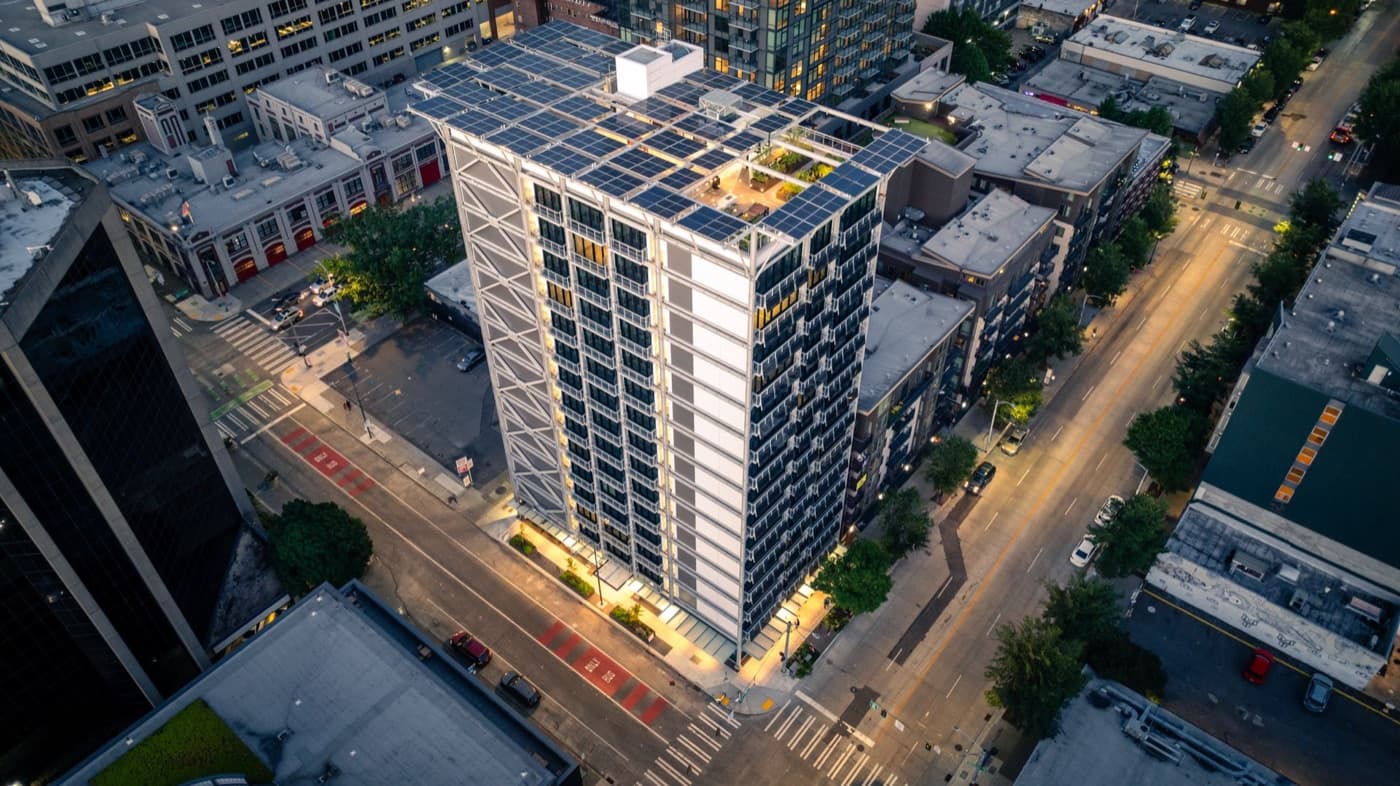 Aerial view of the solar clad 303 Battery Street apartment tower in Seattle at dusk